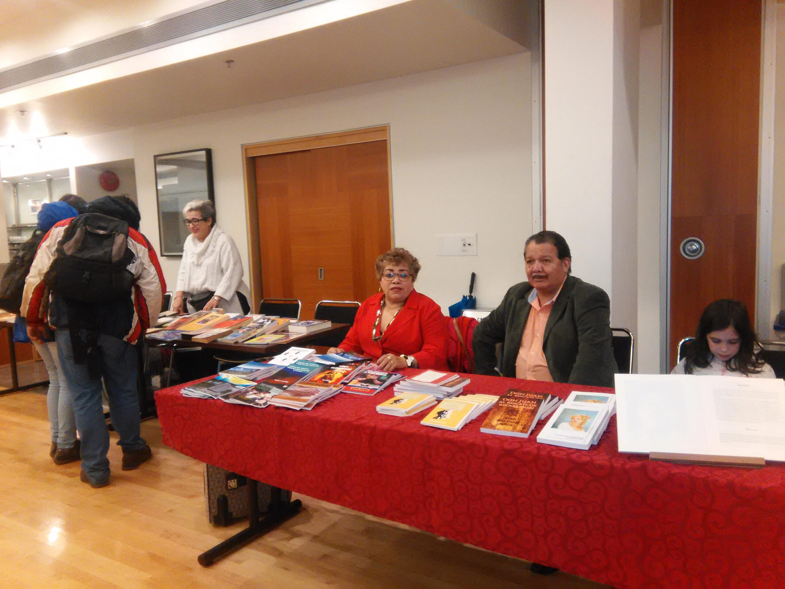 Más autores interactuando con los visitantes en sus stands en la feria del libro